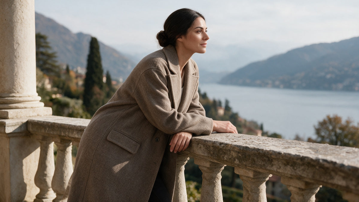 Sofia in cappotto color tortora su una terrazza affacciata sul lago.