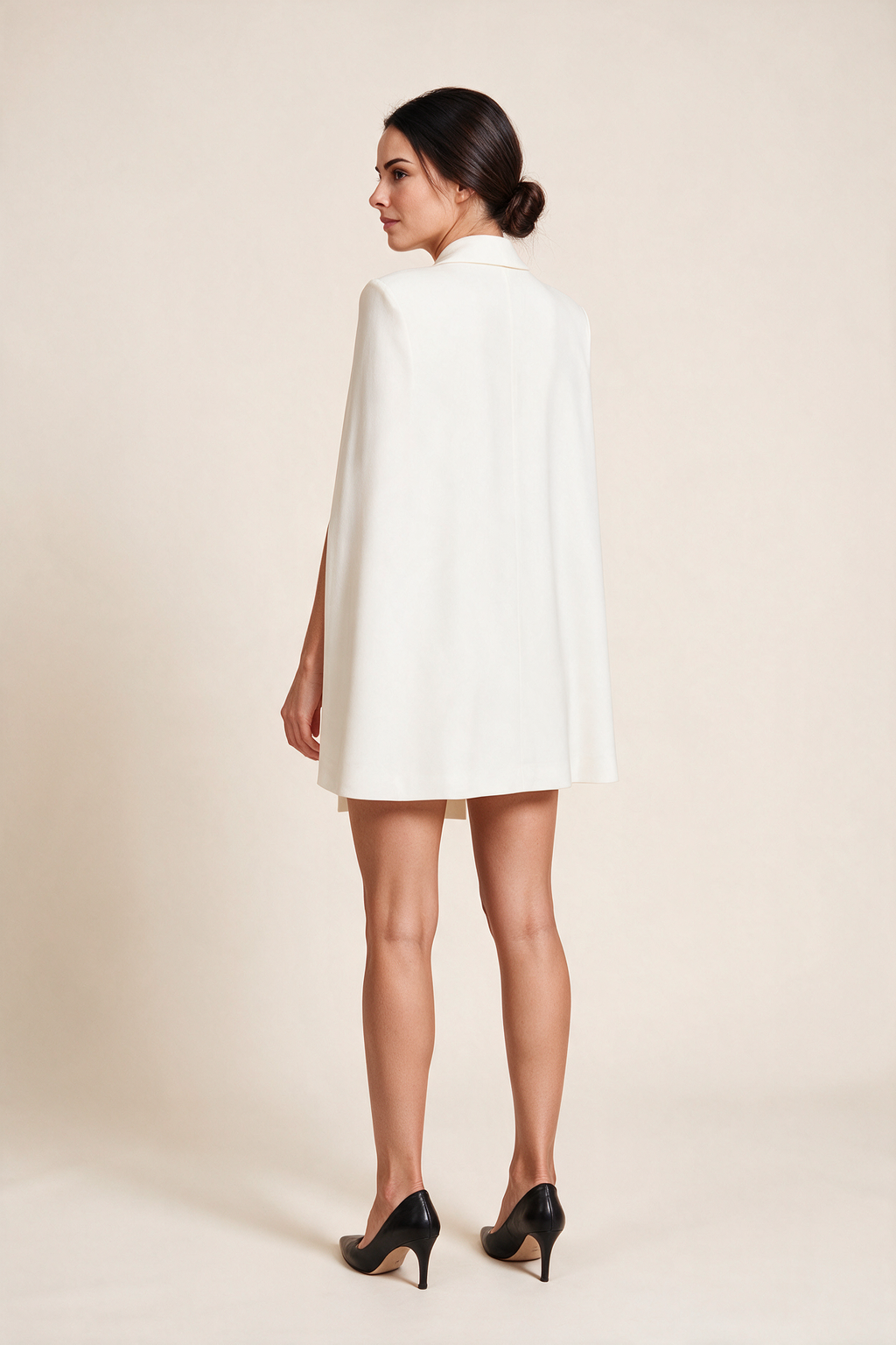 Short belted cape dress — Ivory, worn by Sofia, rear view looking over her shoulder
