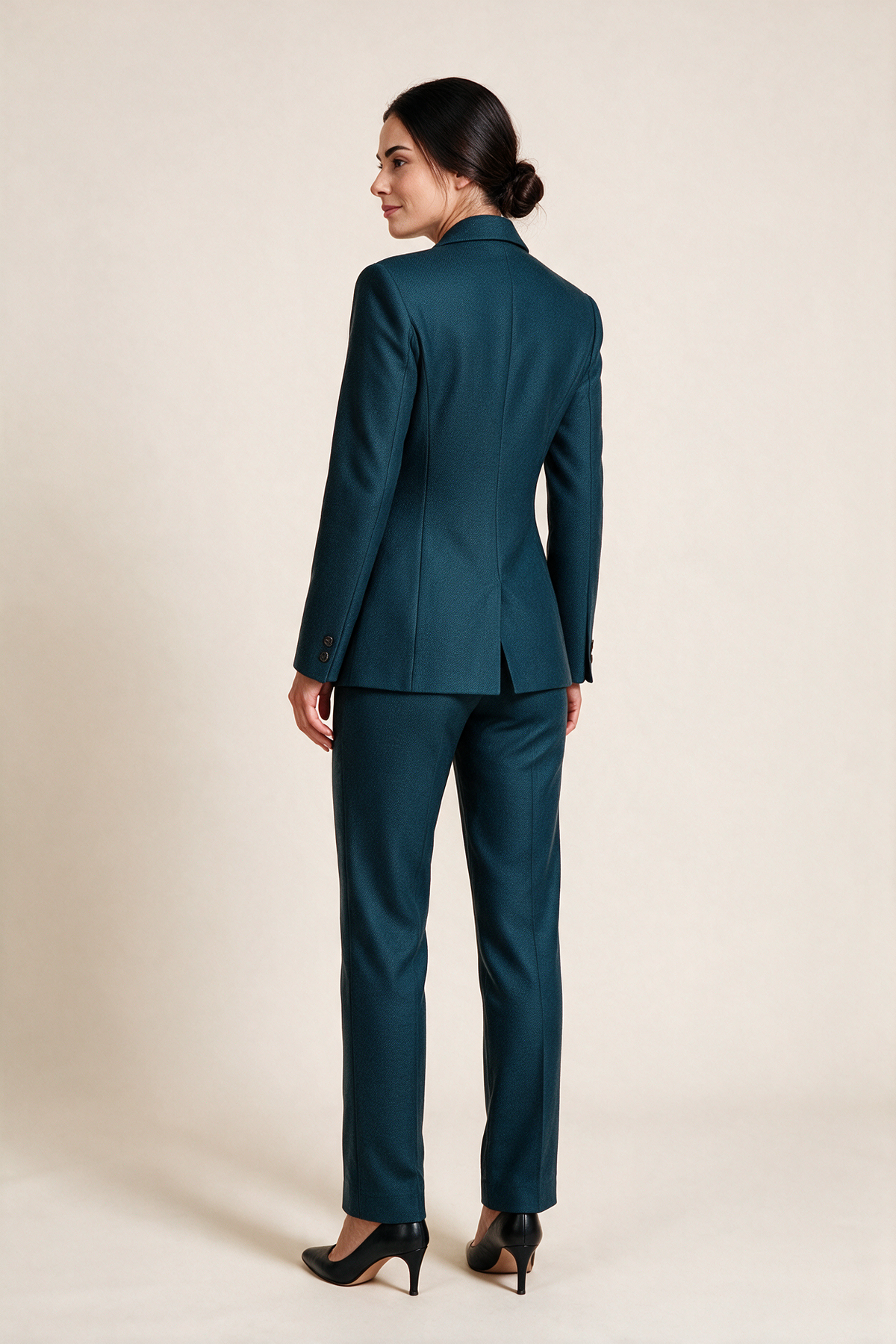 Double-breasted suit with ankle-length trousers — Petrol blue, worn by Sofia, rear view looking over her shoulder