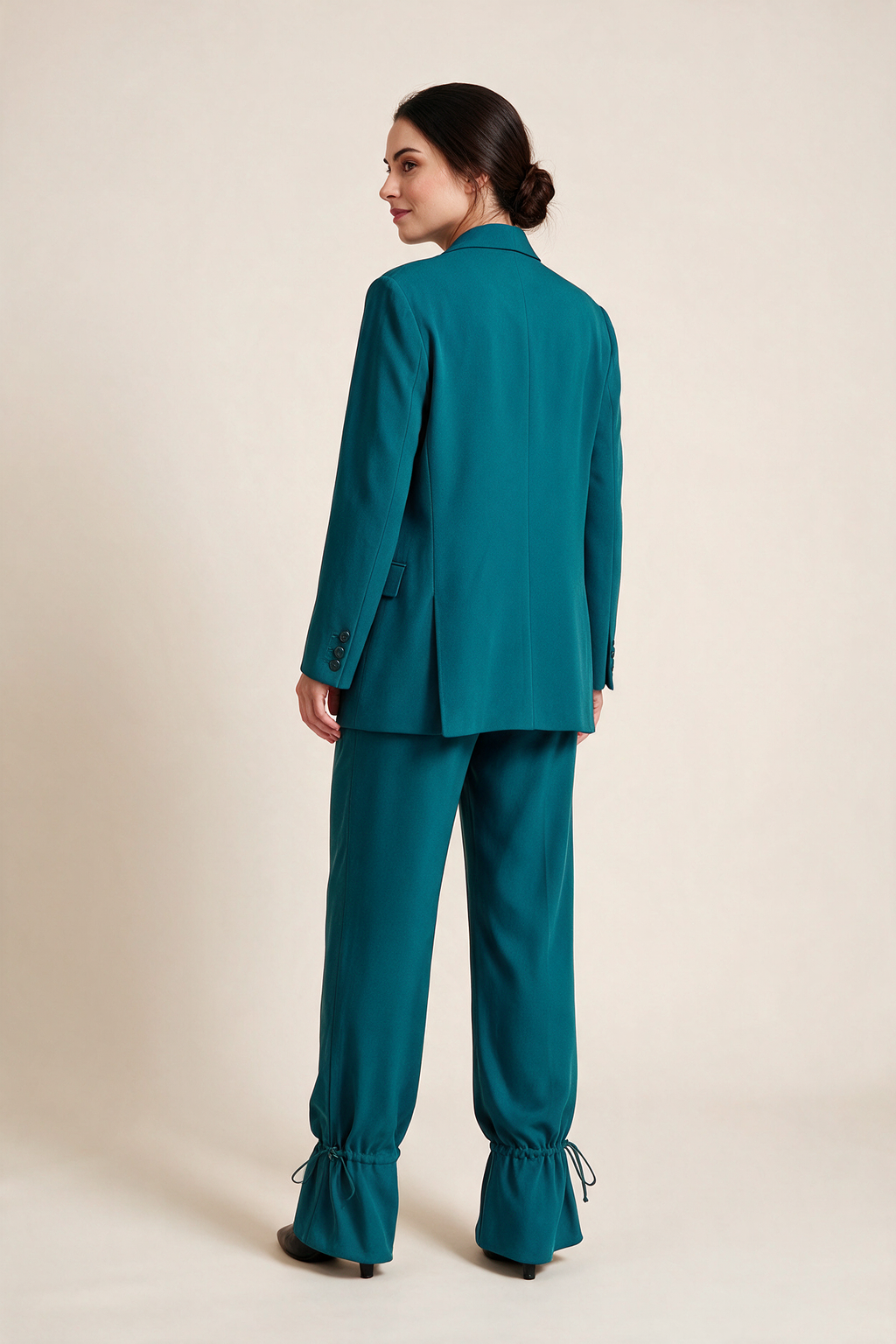 Double-breasted suit with gathered hems — Teal, worn by Sofia, rear view looking over her shoulder